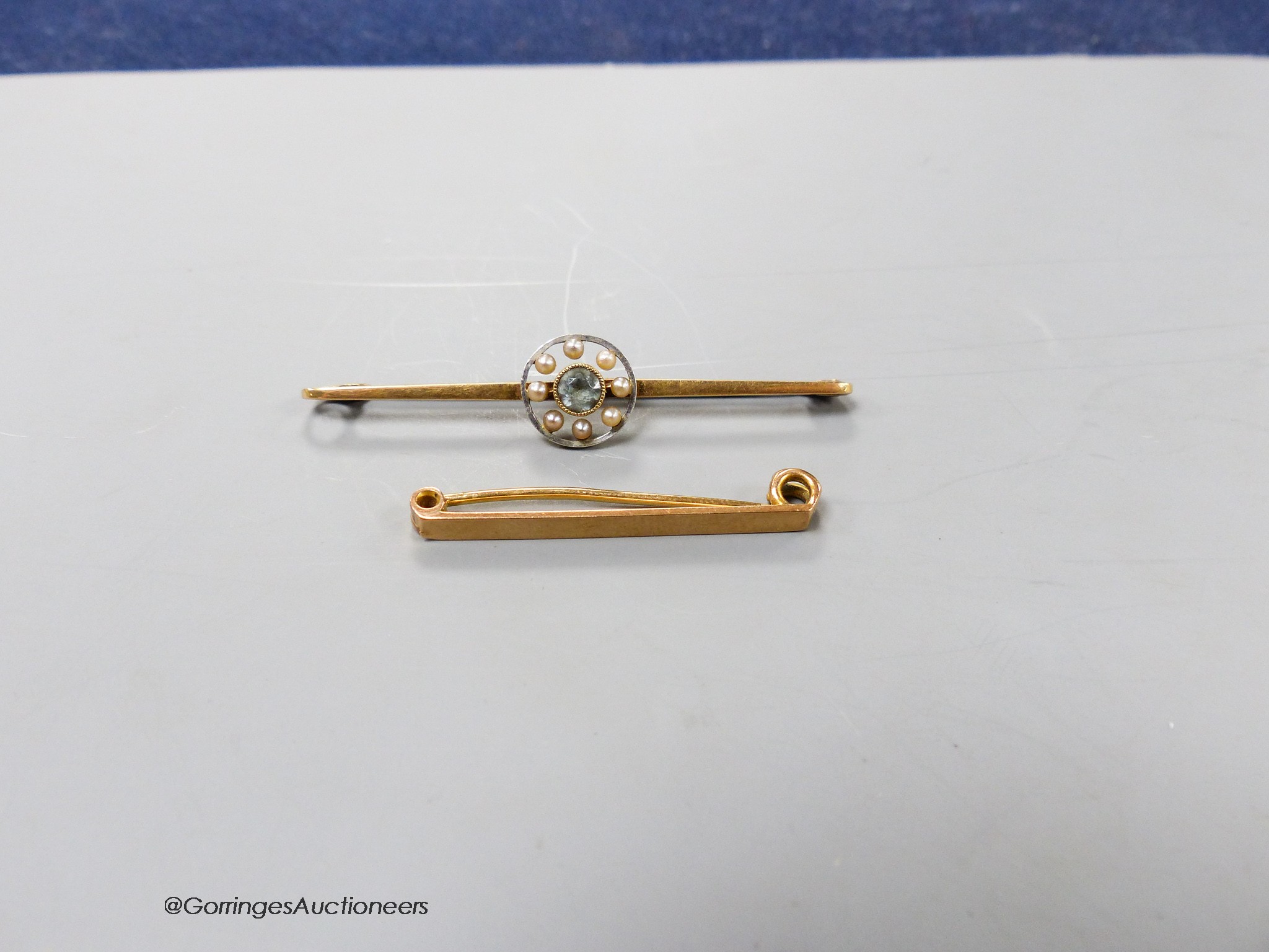 An Edwardian 15ct, aquamarine and seed pearl set bar brooch, 56mm, gross 3.5 grams and a 9ct bar brooch, 2 grams.